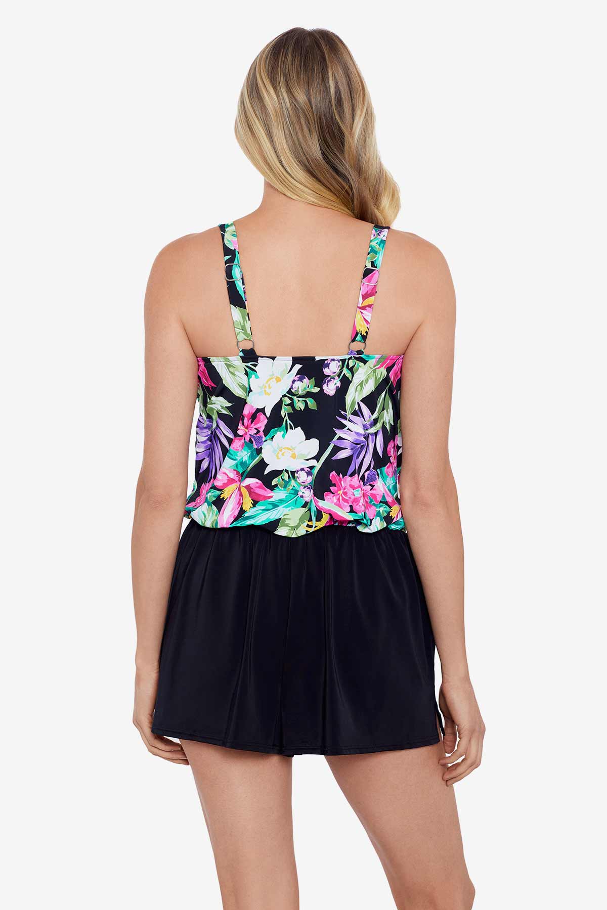 Woman faced away wearing a multicolored tropical printed romper swimsuit