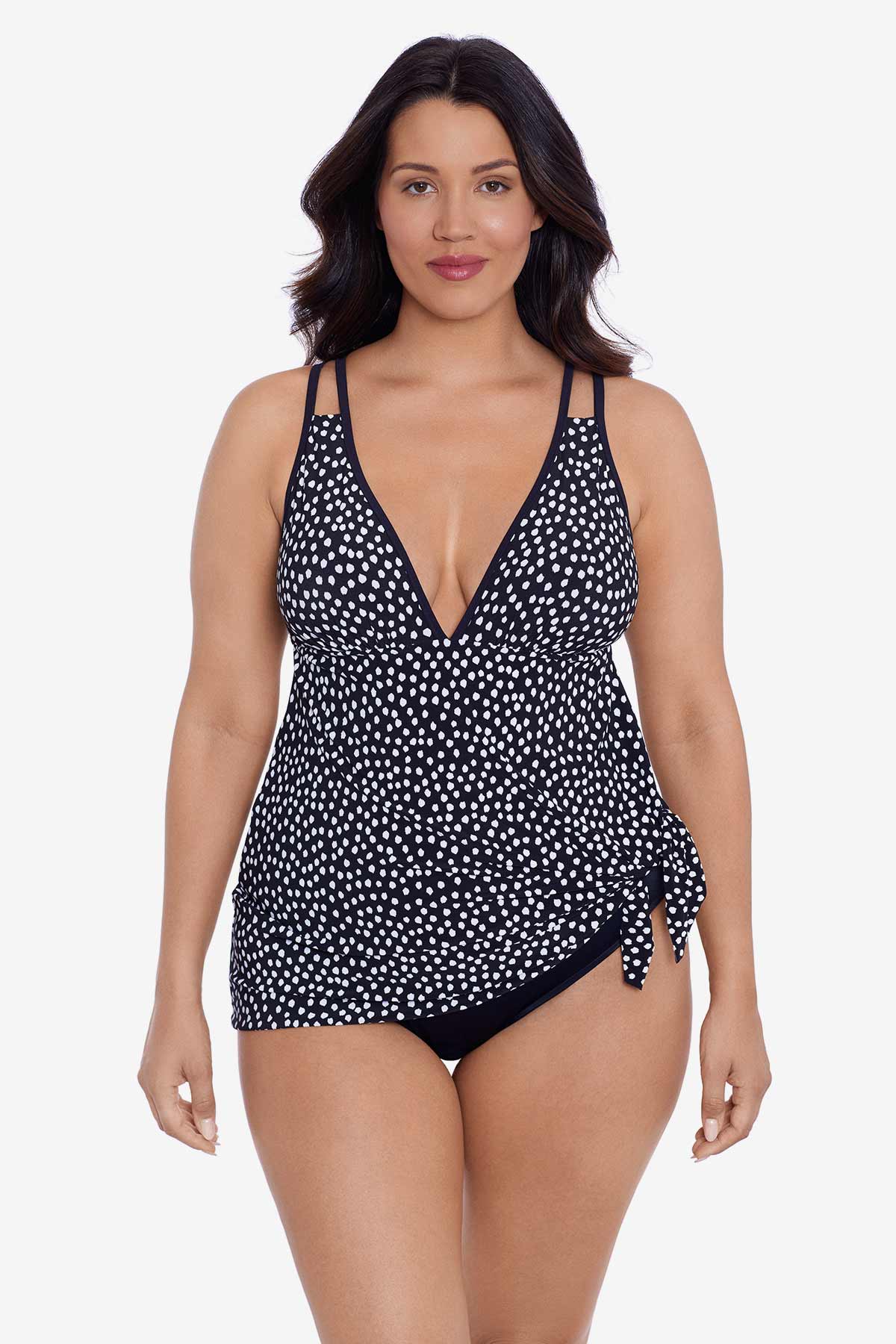Woman wearing a black and white polka dot swim dress tied at the side
