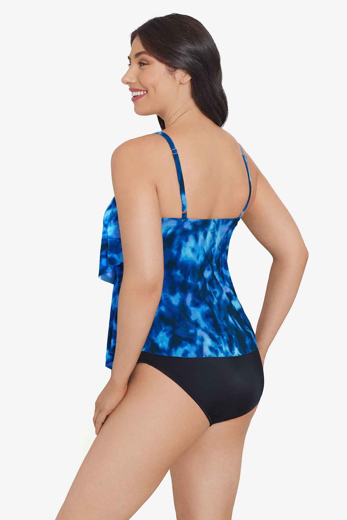 Woman turned left wearing a blue tie dye ruffle tankini top