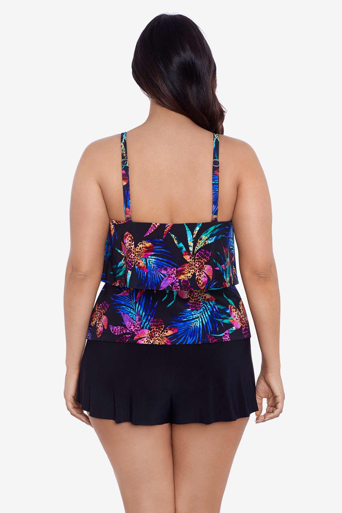 Woman turned away wearing a multicolored tropical printed swim romper