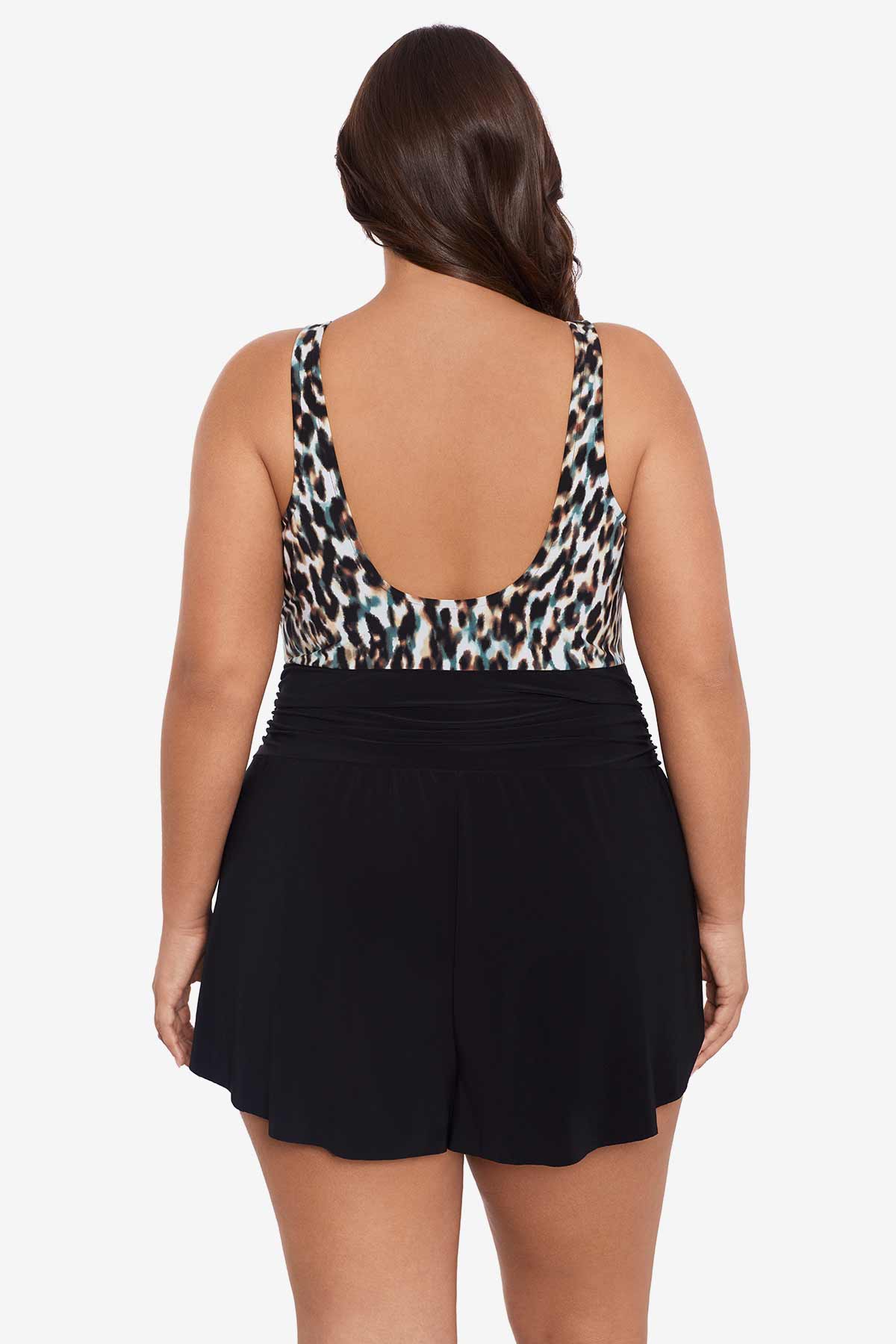 Woman faced away wearing a leopard printed swim romper with black shorts