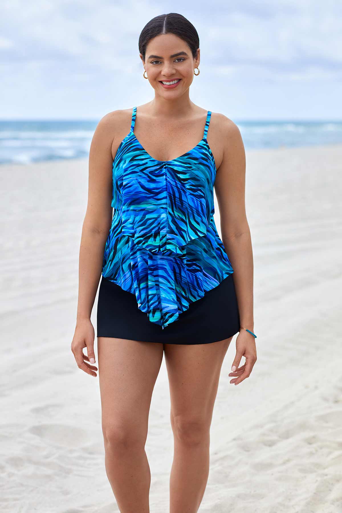 Woman on beach wearing a blue wave printed tankini top