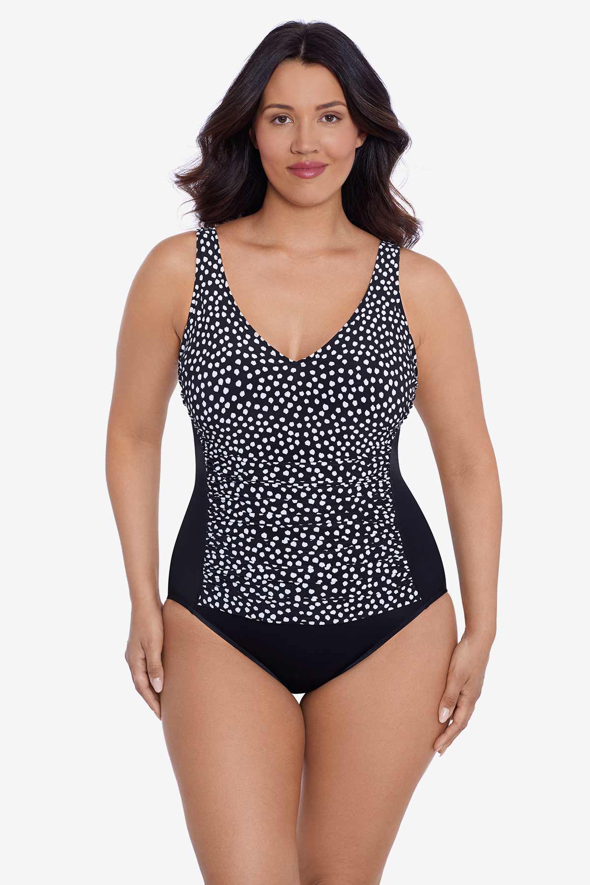 Woman wearing a black and white polka dot one-piece swimsuit