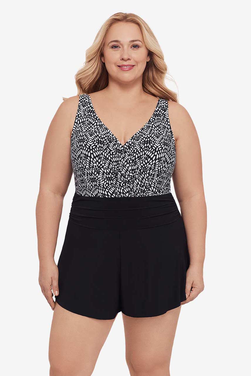 Woman wearing a black and white lace-esque pattern swim romper