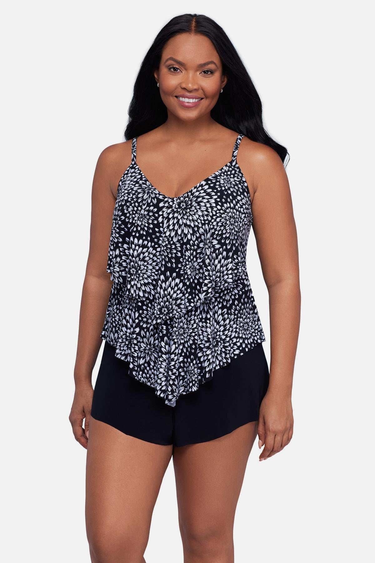 Woman wearing a black and white floral printed tankini top with ruffles