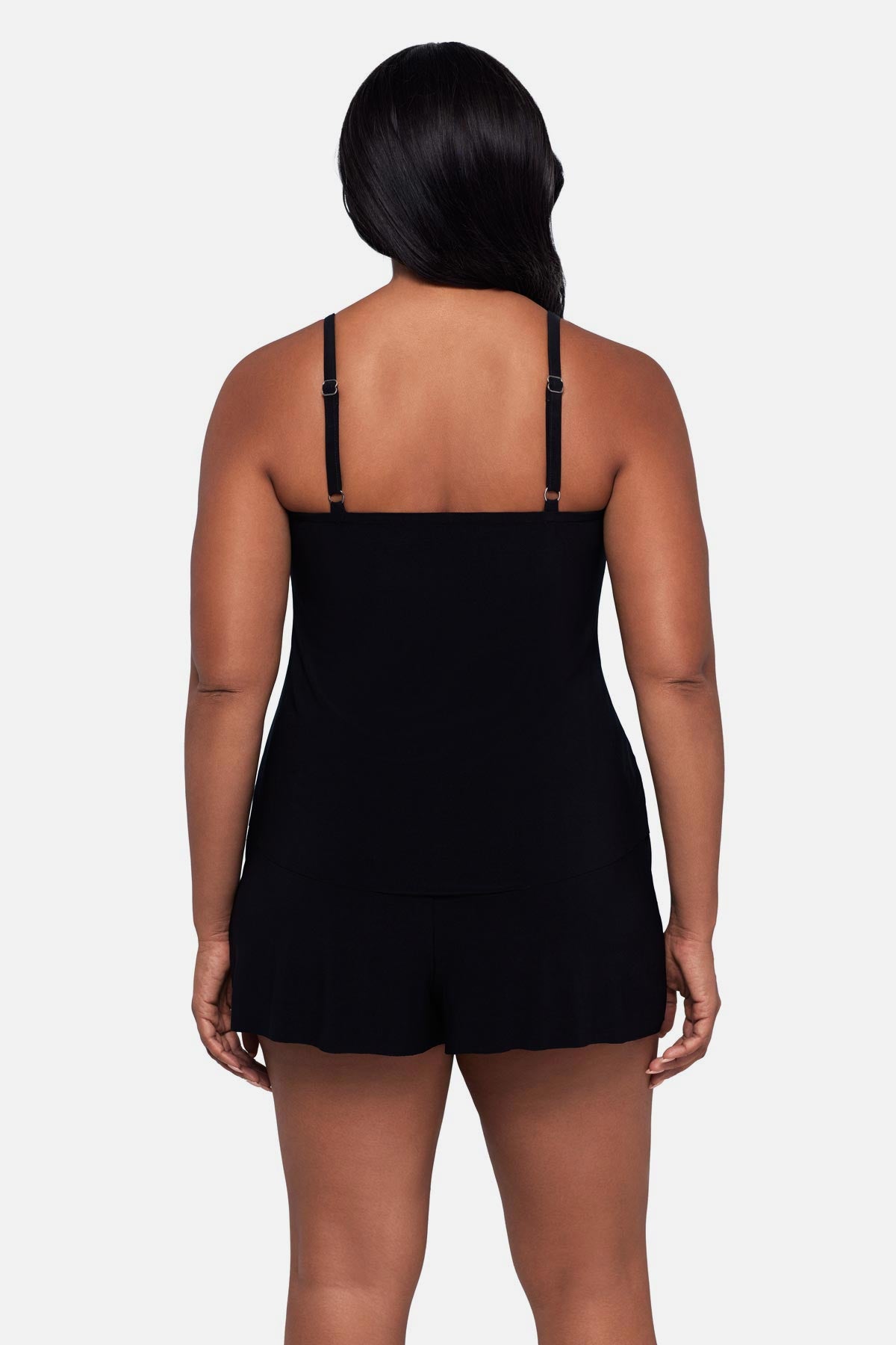 Woman turned away wearing a black and white dot printed romper swimsuit