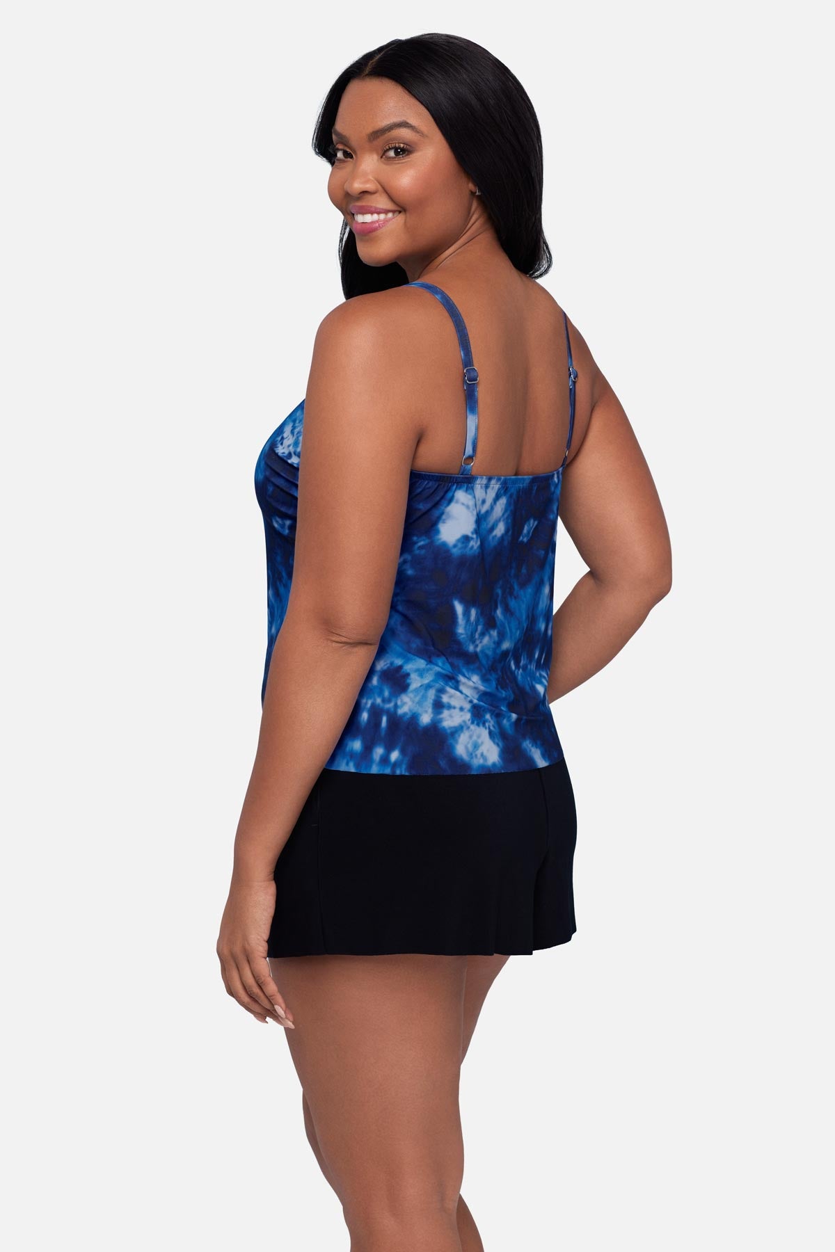 Woman turned left wearing a blue tie dye swim romper