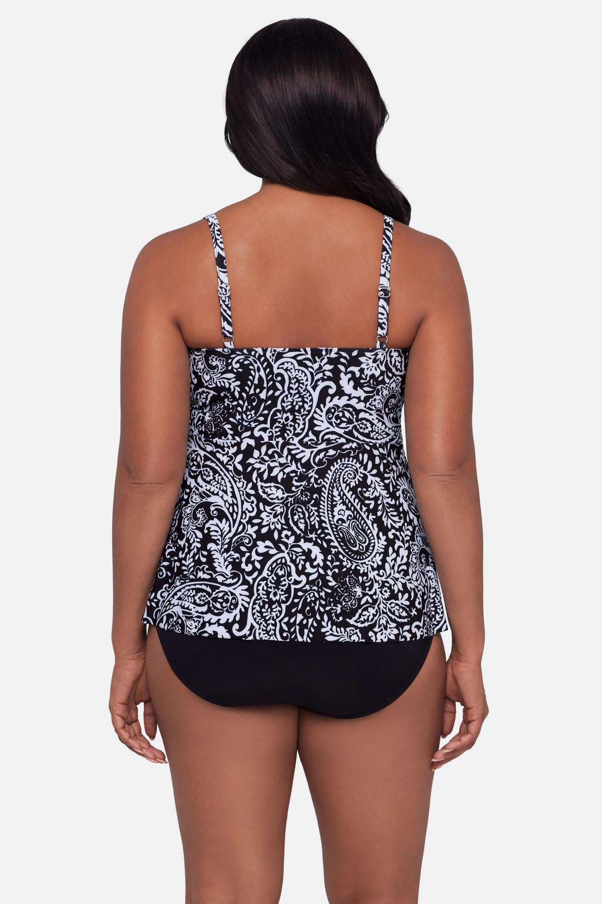 Woman turned away wearing a paisley printed black and white tankini top