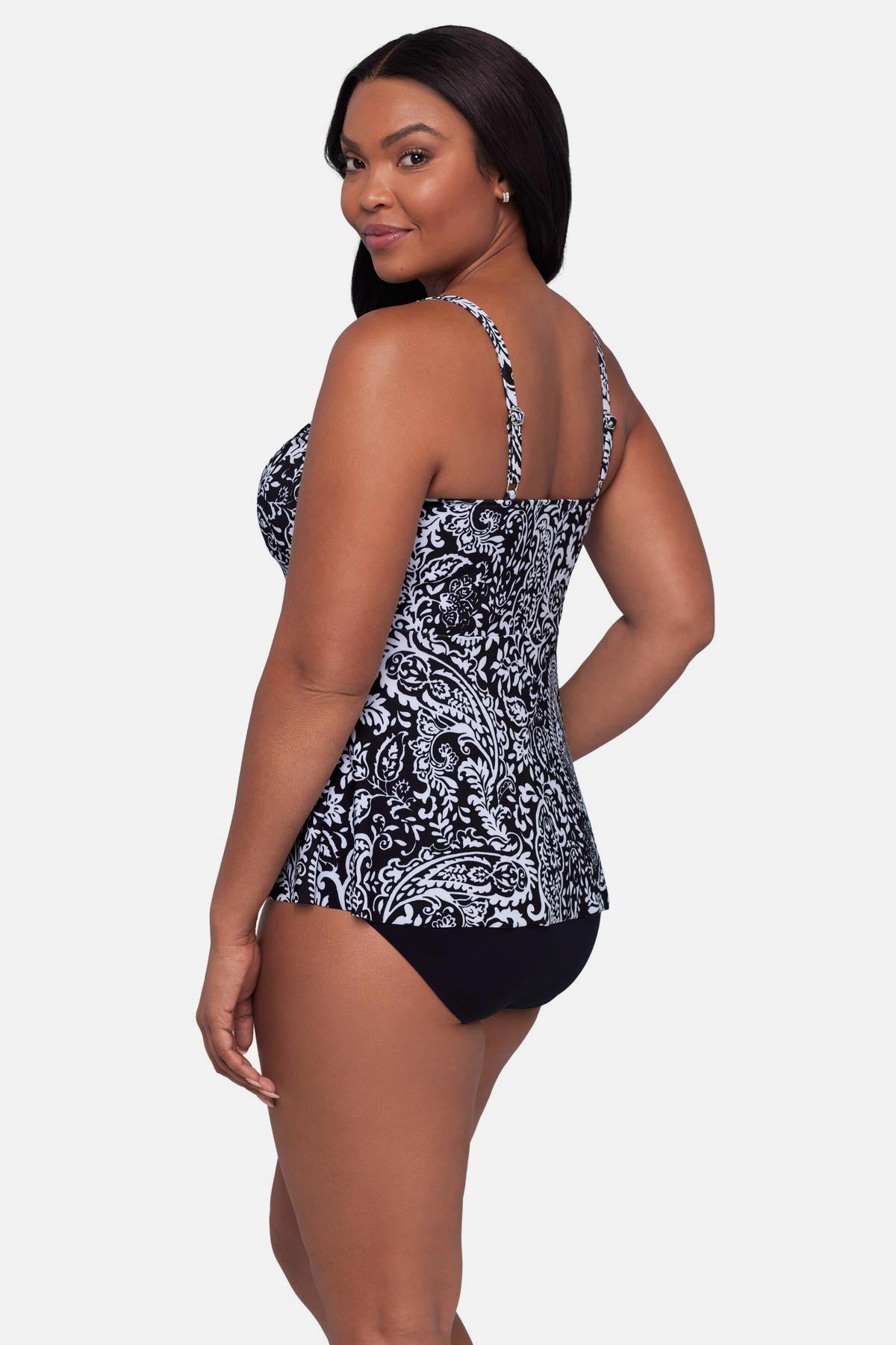 Woman turned left wearing a paisley printed black and white tankini top