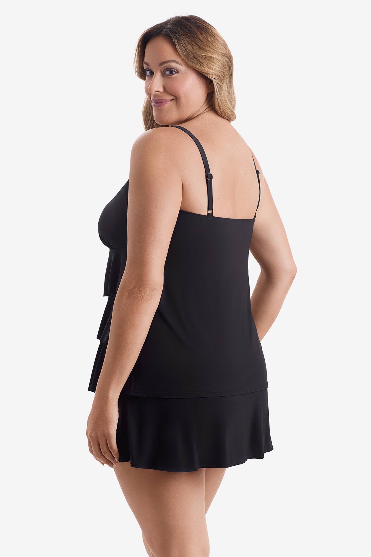 Woman faced left wearing a black tiered one-piece swimsuit