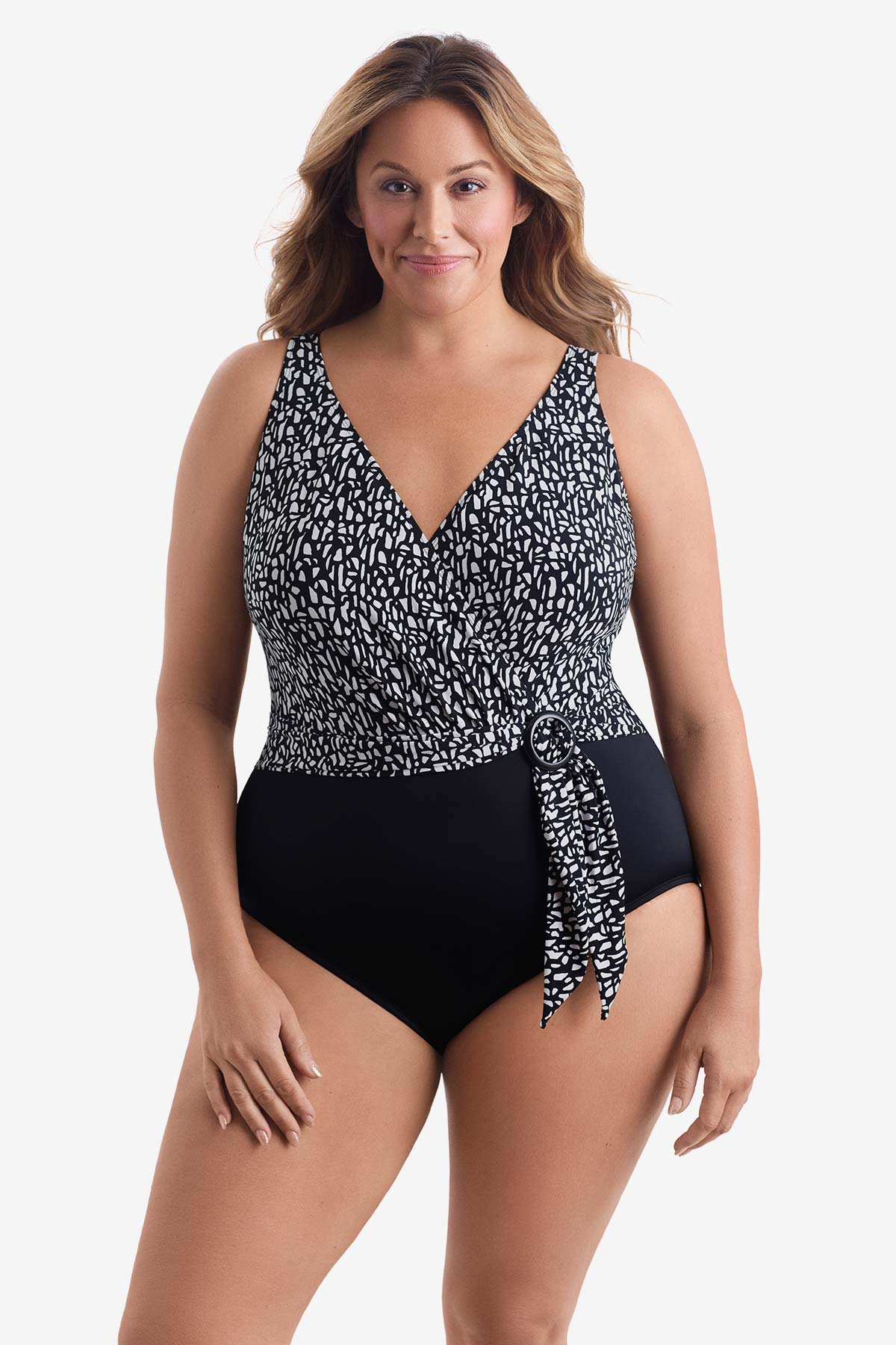 Woman wearing a black and white paper mache printed one-piece swimsuit with a belt effect