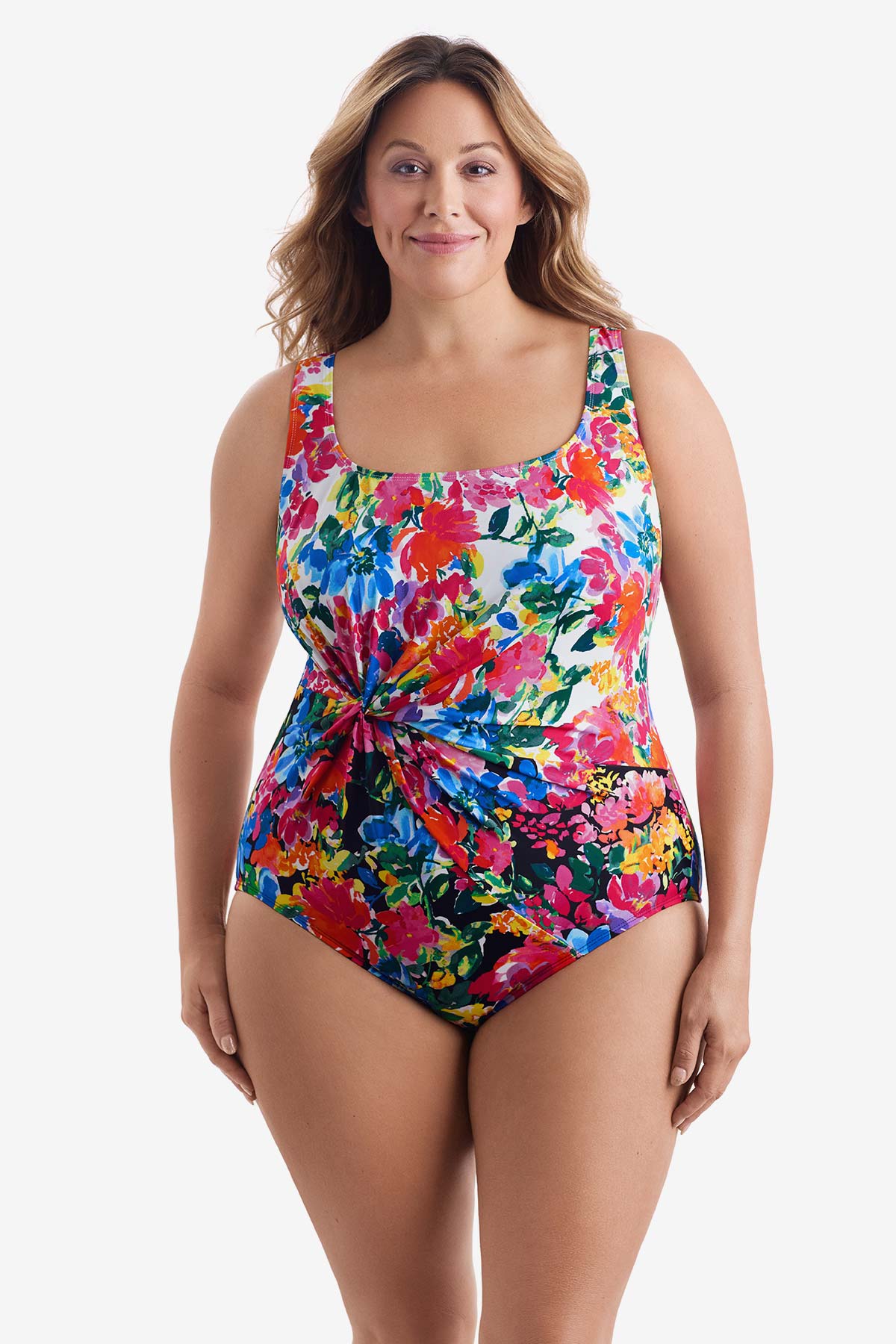 Woman wearing a multicolored floral one-piece swimsuit with a twist on the side