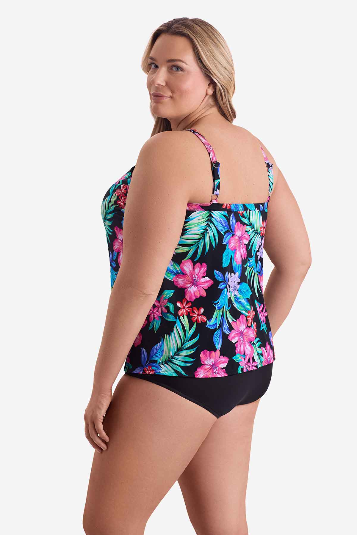 Woman faced left wearing a multicolored tropical printed tankini top
