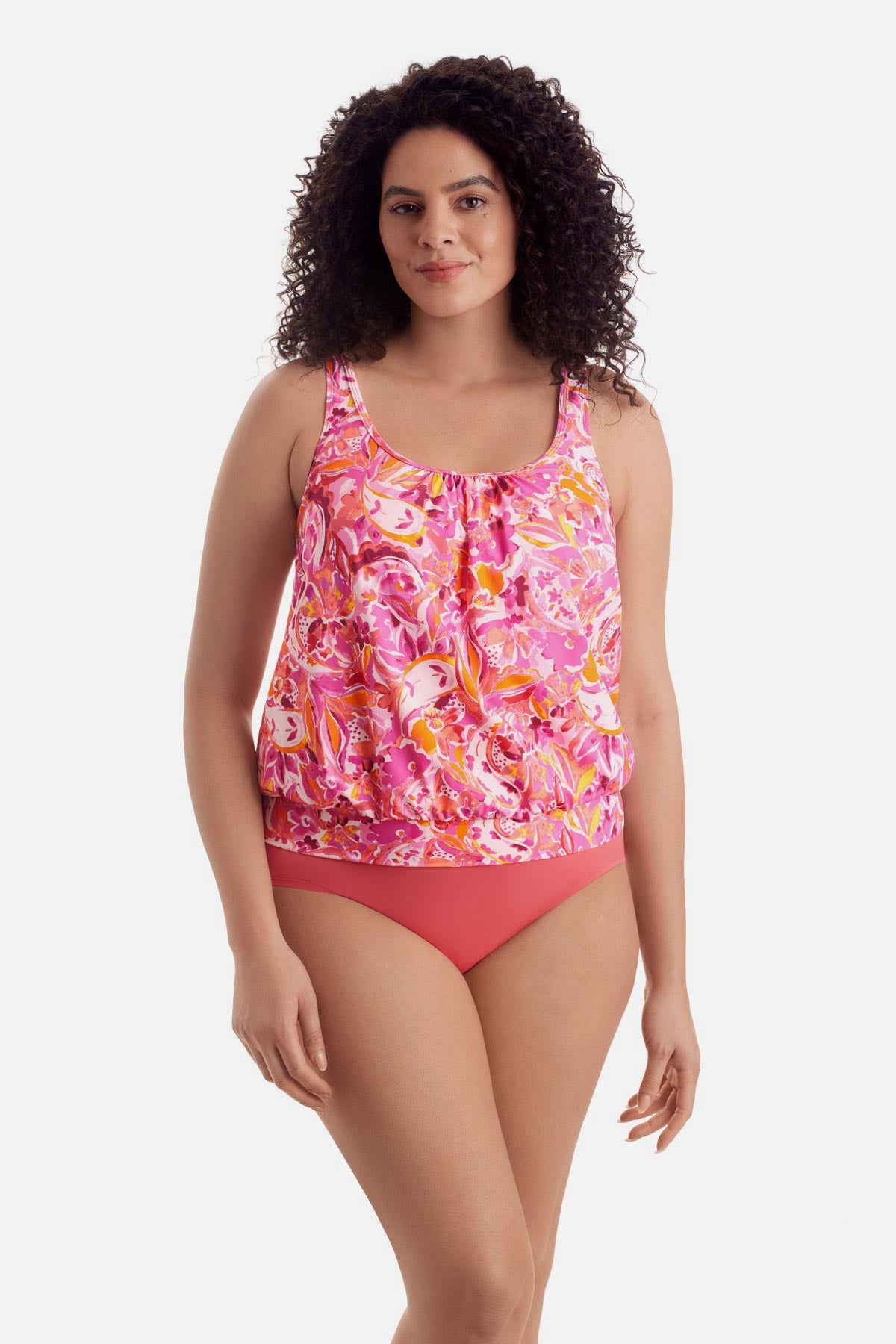Woman wearing a pink floral printed shirred neck blouson tankini top
