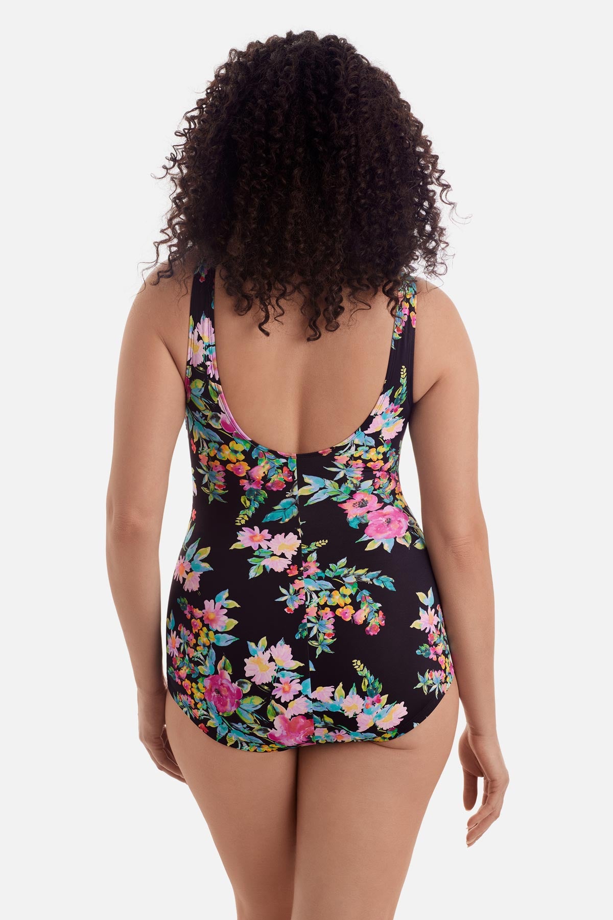 Woman turned away wearing a multicolored floral printed one-piece swimsuit