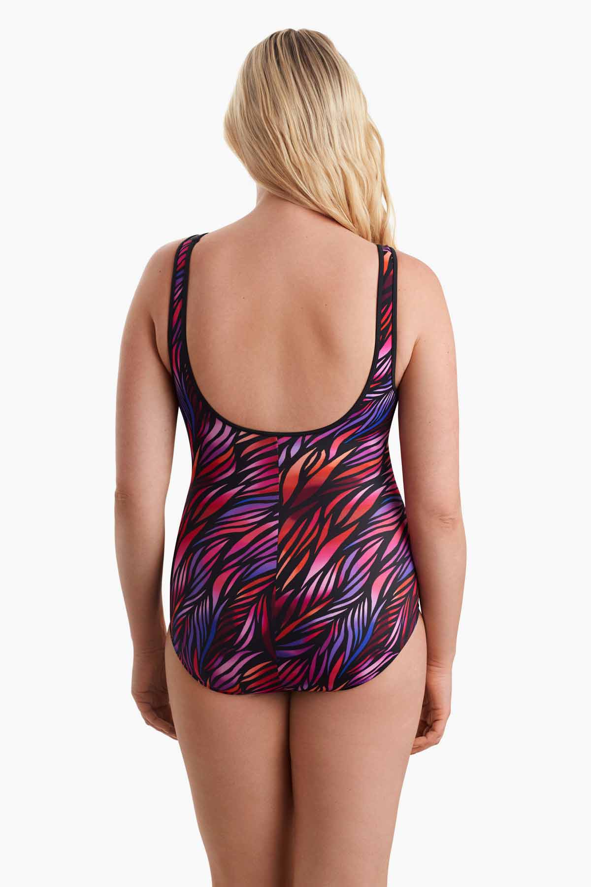 Woman facing away wearing a multicolored one-piece swimsuit