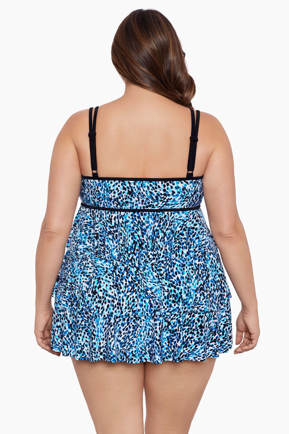 Woman turned away wearing a multi-blue speckled swim dress with tiered ruffles
