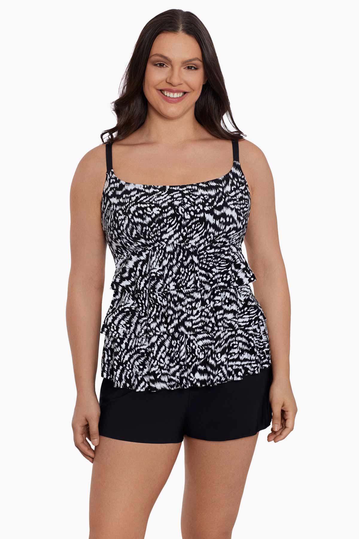 Woman wearing a black and white abstract printed ruffled skirtini swimsuit