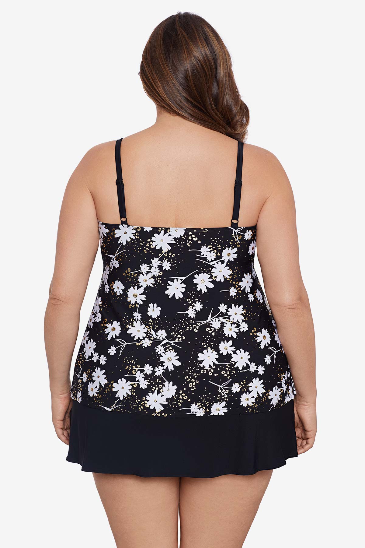 Woman faced away wearing a small white flower printed black skirtini swimsuit with ruffles