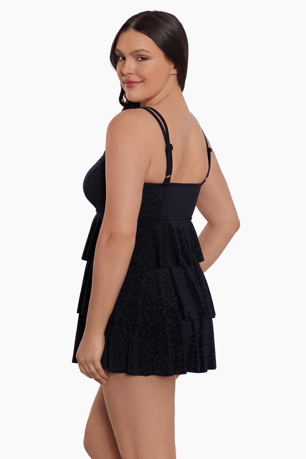Woman turned left wearing a black faint animal printed tiered swim dress