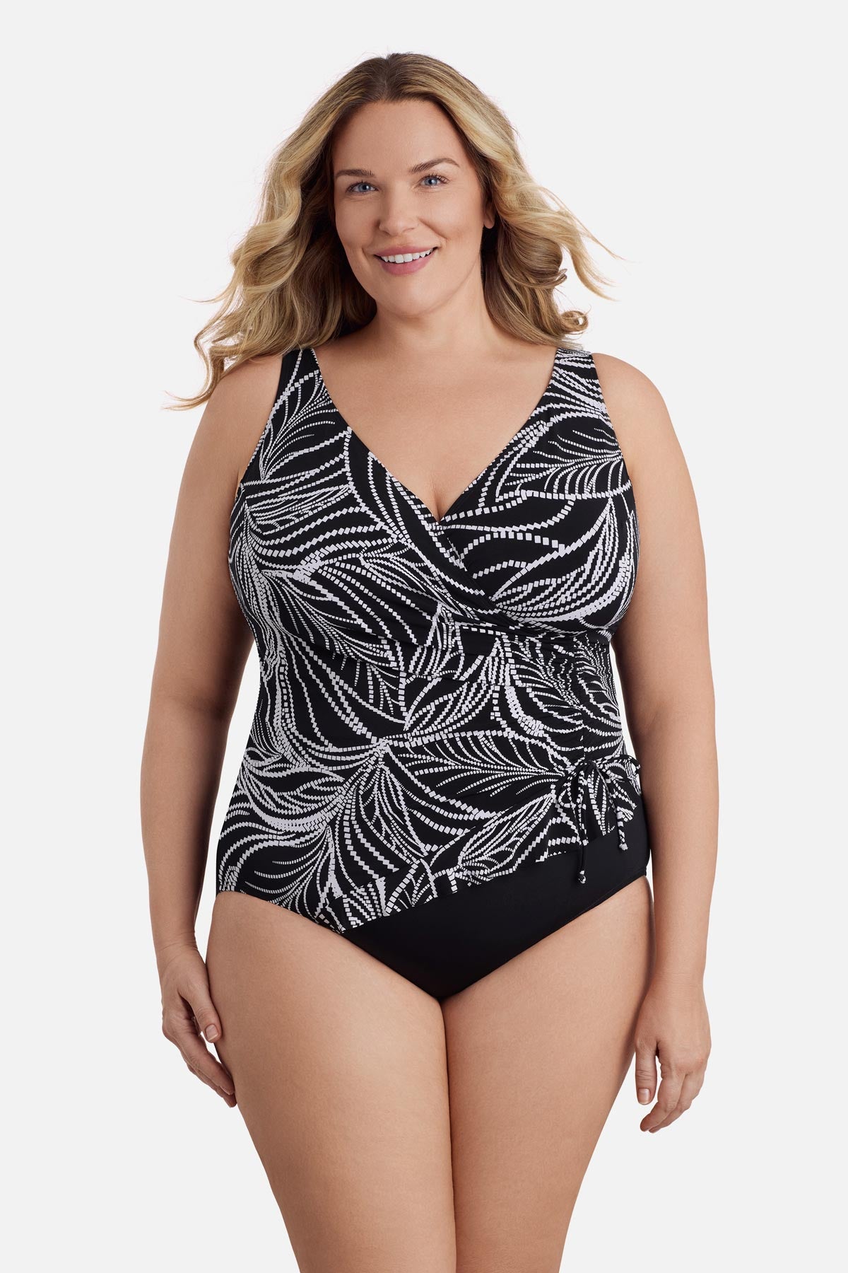 Woman wearing a black and white dotted leaf pattern one-piece swimsuit