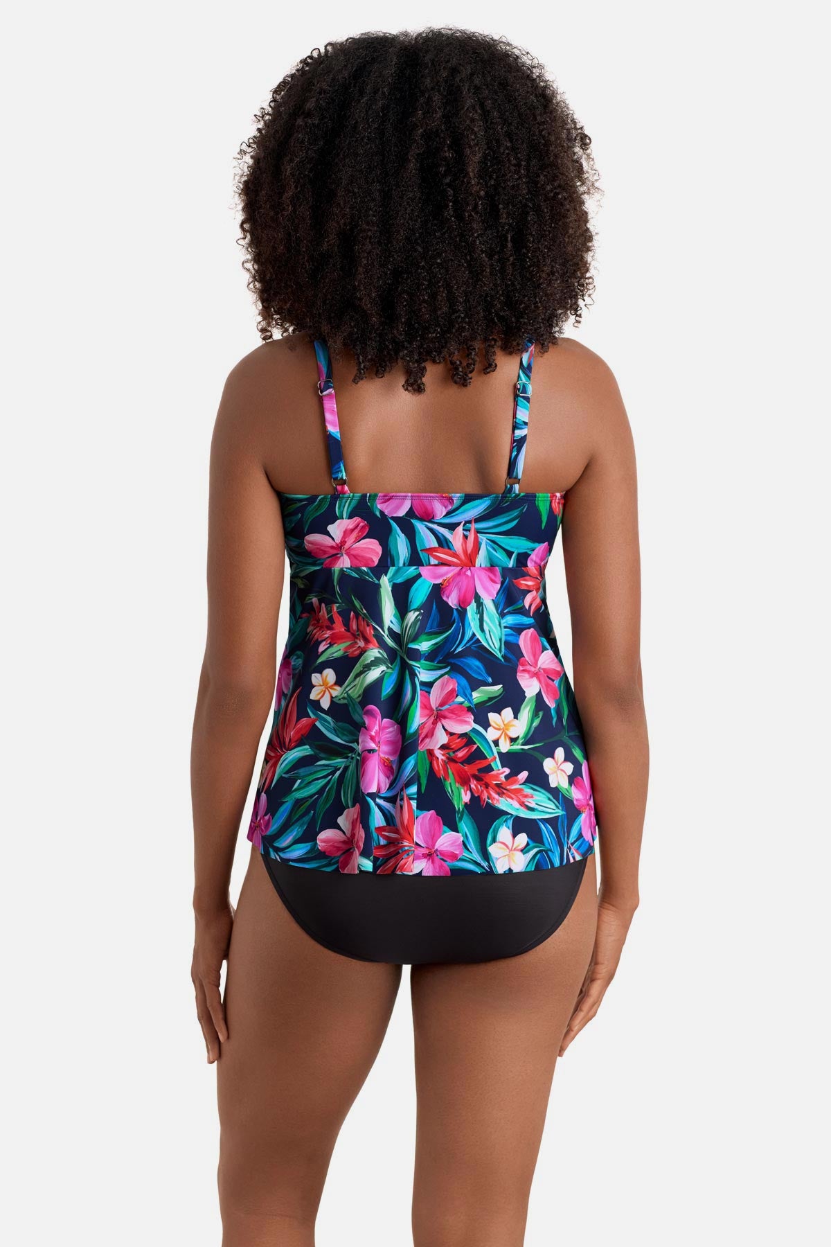 Woman faced away wearing a multicolor floral and palm leaf print tankini top