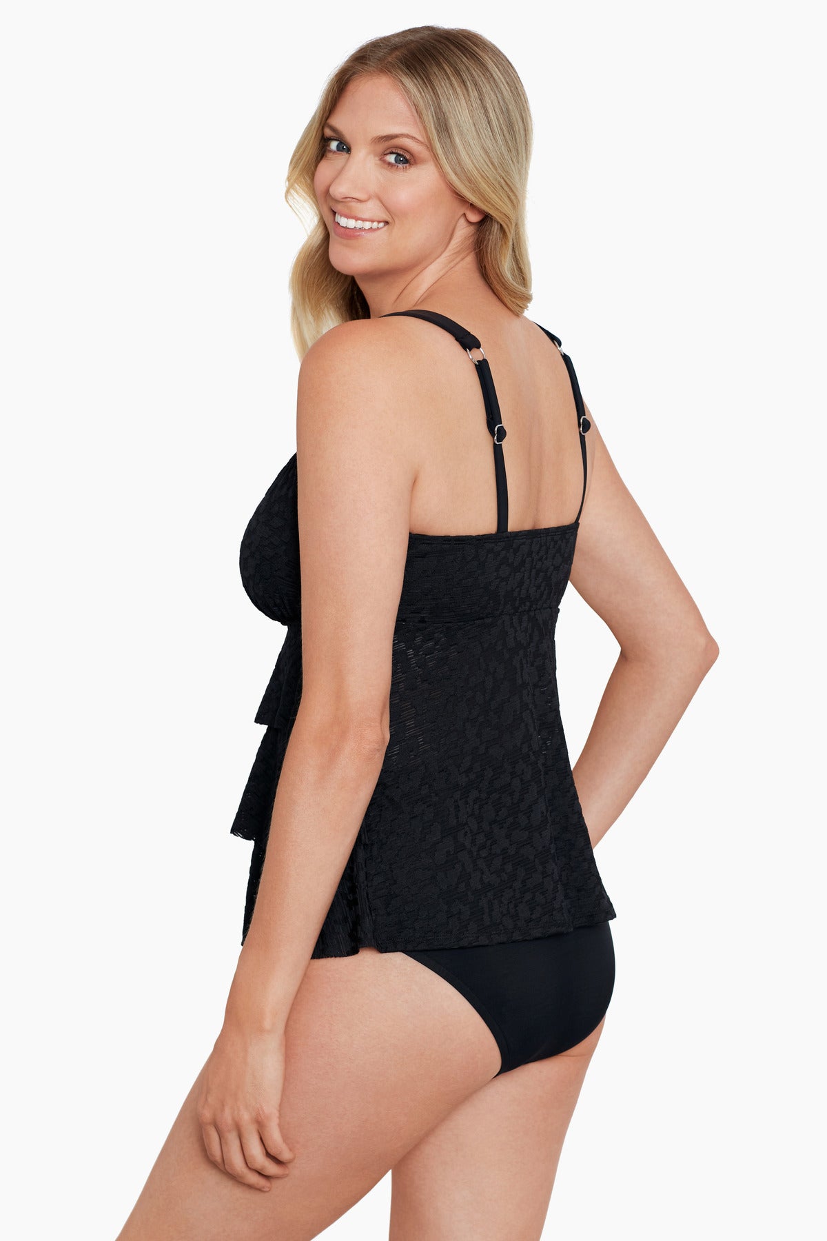 Woman turned left wearing a black with light animal print triple tier tankini top