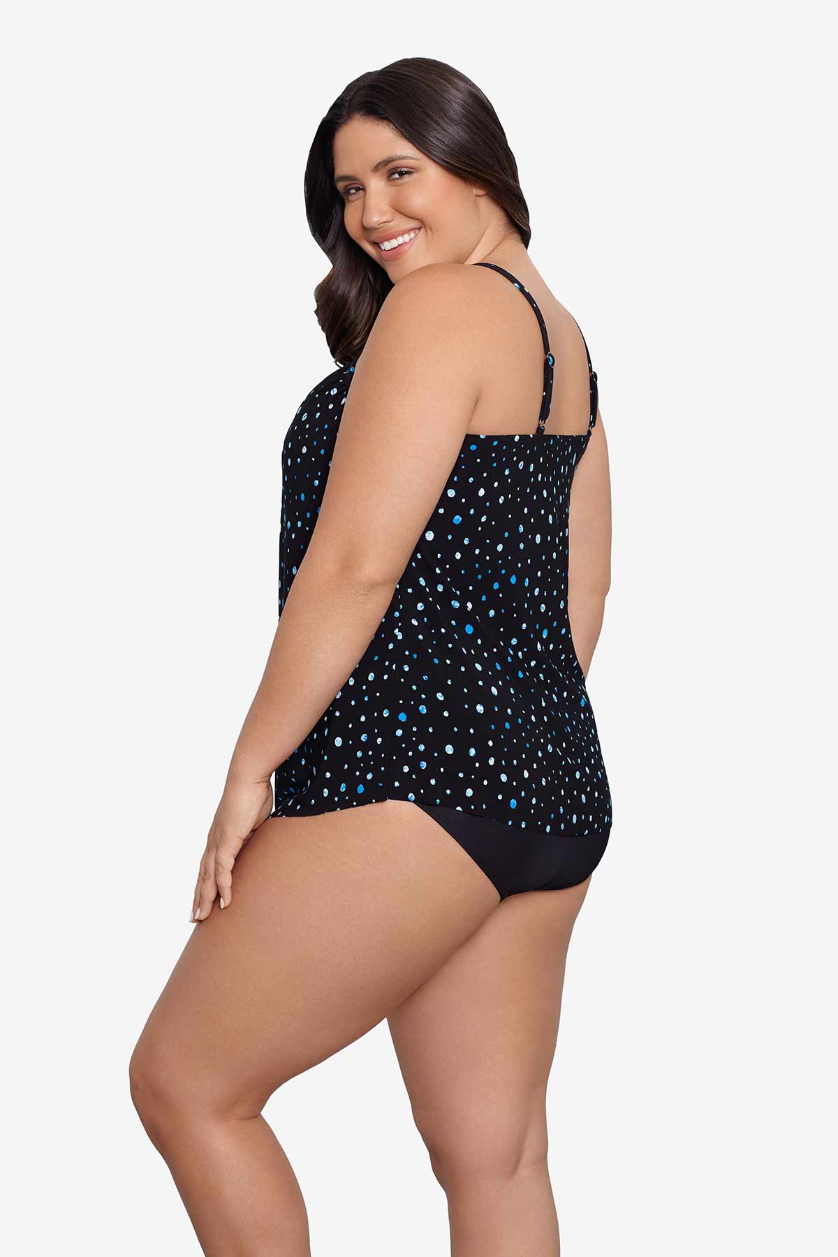 Woman faced left wearing a black and blue polka dotted tankini top
