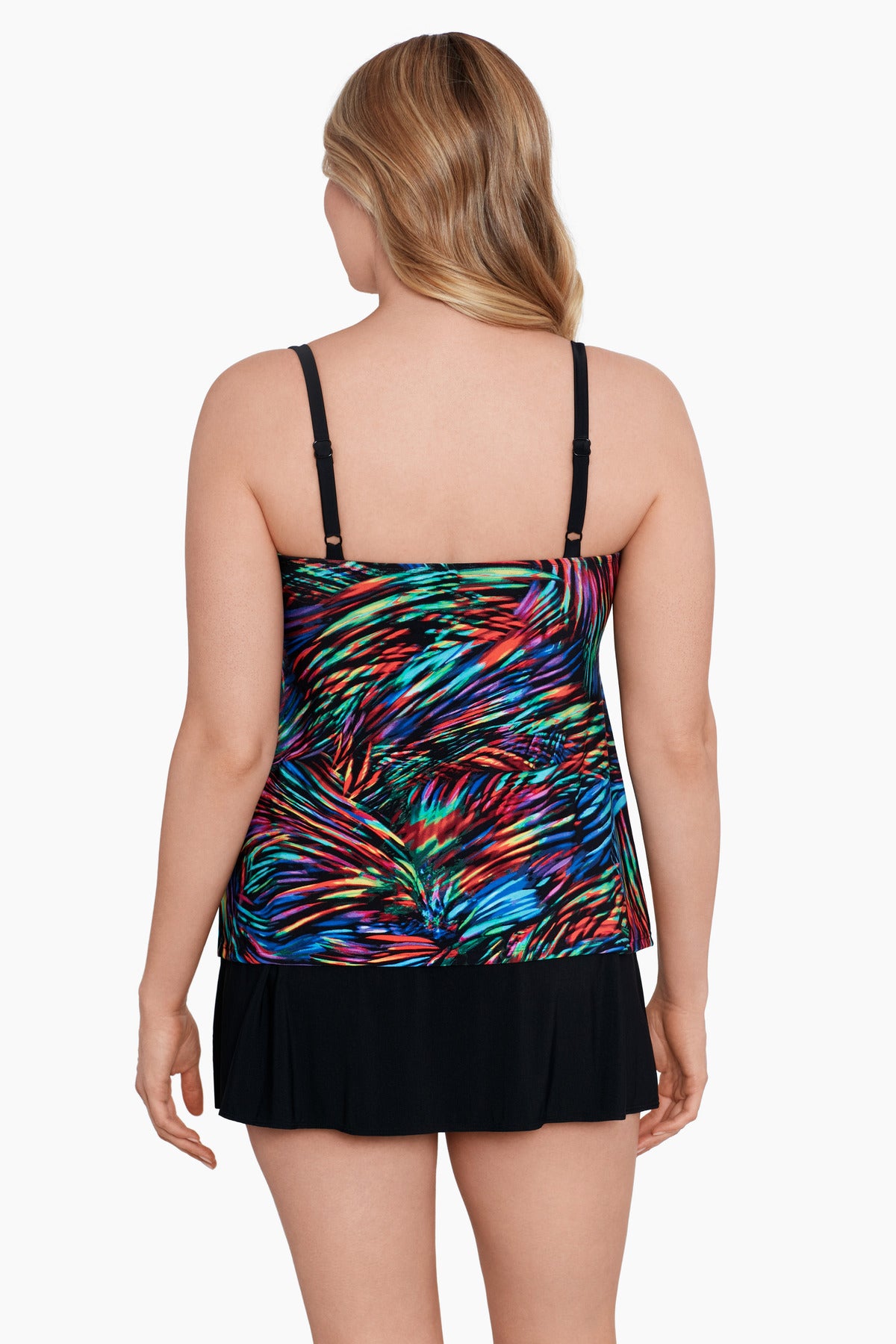 Woman turned away wearing a rainbow light burst pattern ruffle one-piece skirtini swimsuit