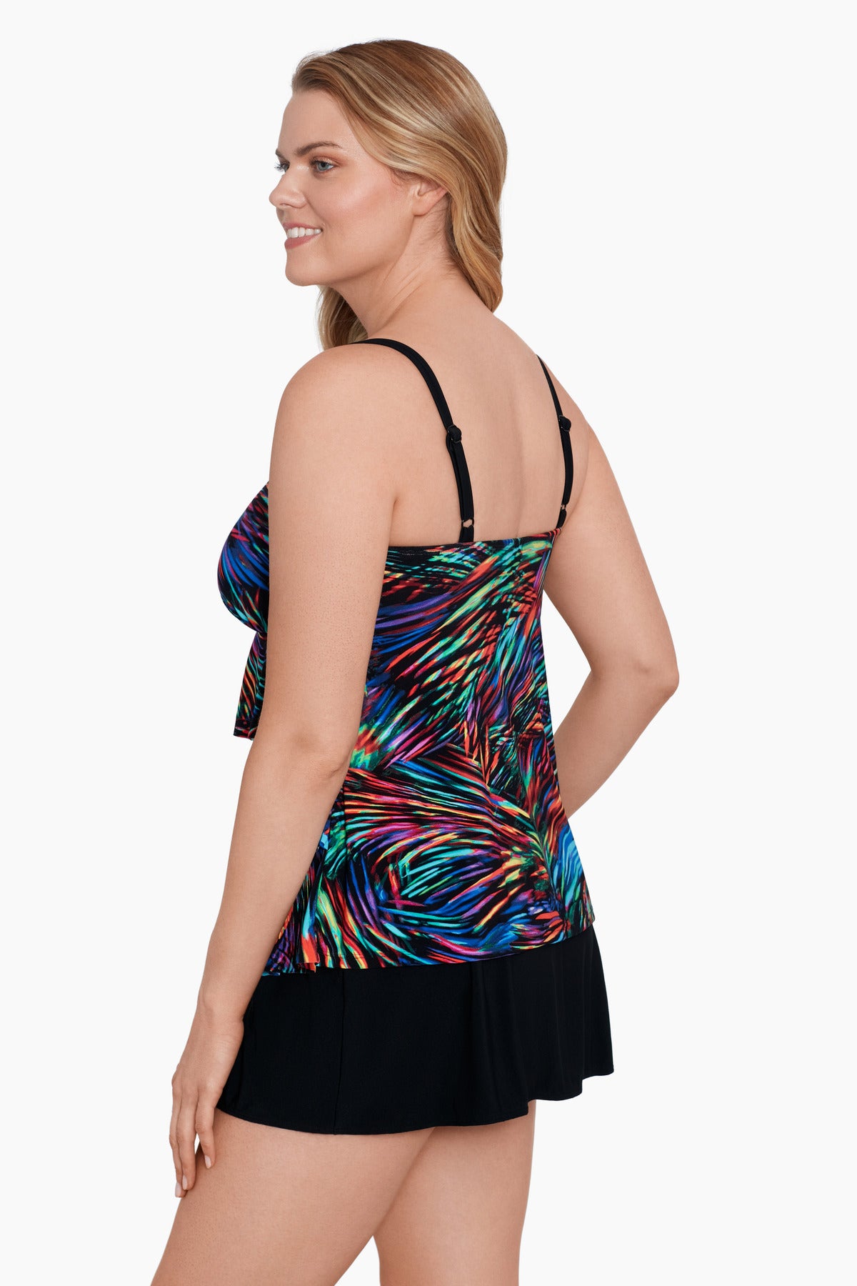 Woman turned left wearing a rainbow light burst pattern ruffle one-piece skirtini swimsuit