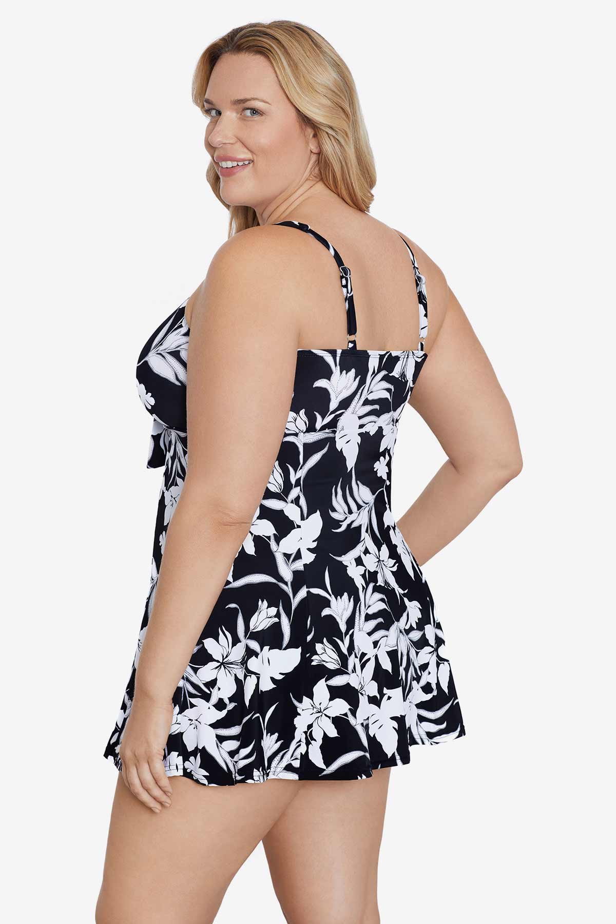 Woman turned left wearing a black and white floral printed bow front swim dress