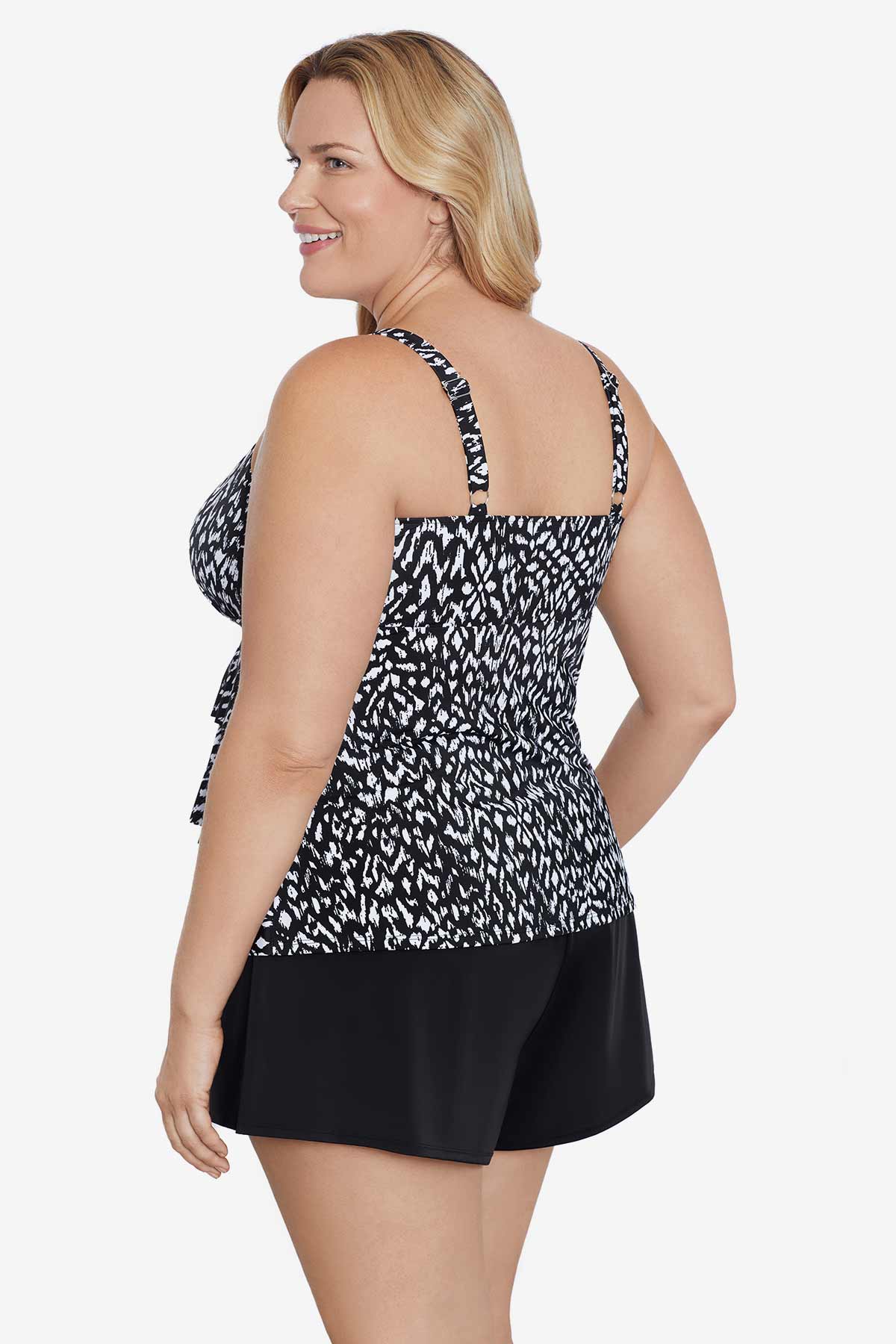 Woman faced left wearing a black and white scaley printed tiered tankini top