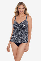 Woman wearing a black and white scaley printed tiered tankini top