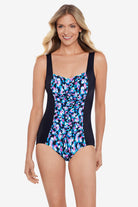 Woman wearing a multicolored abstract printed one-piece swimsuit