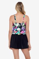 Woman faced away wearing a multicolored tropical printed romper swimsuit