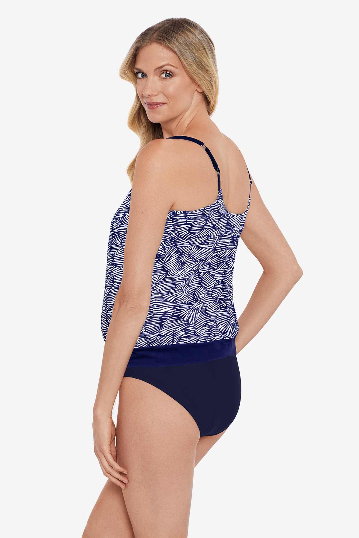 Woman faced left wearing a blue and white abstract pattern blouson tankini top