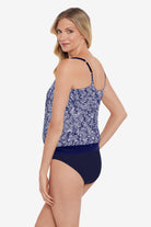 Woman faced left wearing a blue and white abstract pattern blouson tankini top