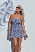 Woman next to wall wearing a blue and white abstract pattern swim dress