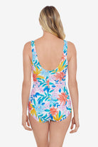 Woman faced away wearing a multicolored tropical print one-piece swimsuit