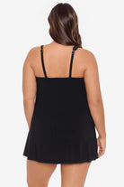 Woman turned away wearing a black swim dress with different straps