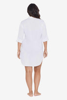 Woman faced away wearing a white shirt dress swim cover up