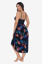 Woman faced left wearing a tropical printed swim wrap cover up with tassels