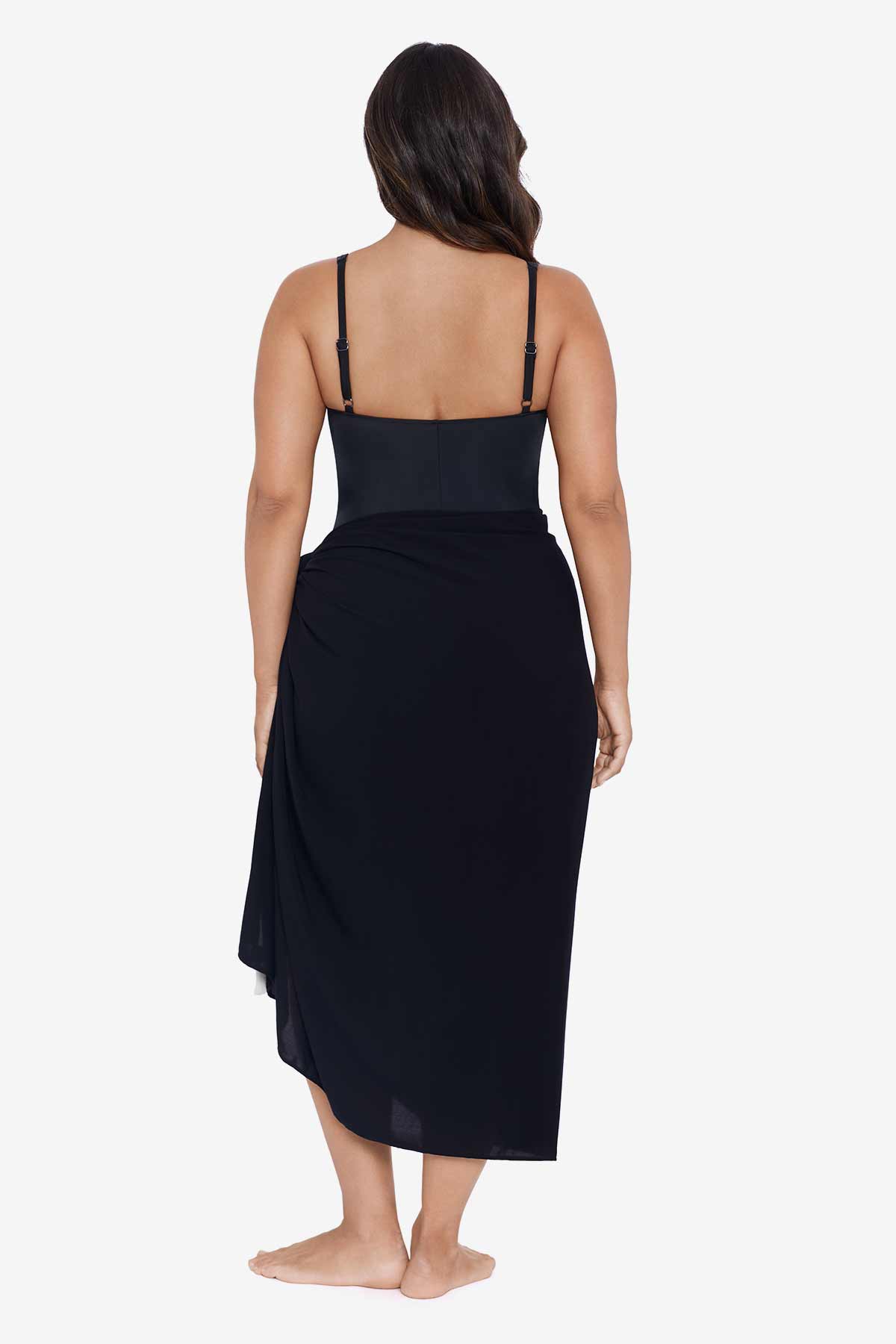 Woman faced away wearing a black swim wrap cover up with tassels