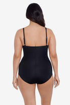 Woman faced away wearing a black one-piece swimsuit 