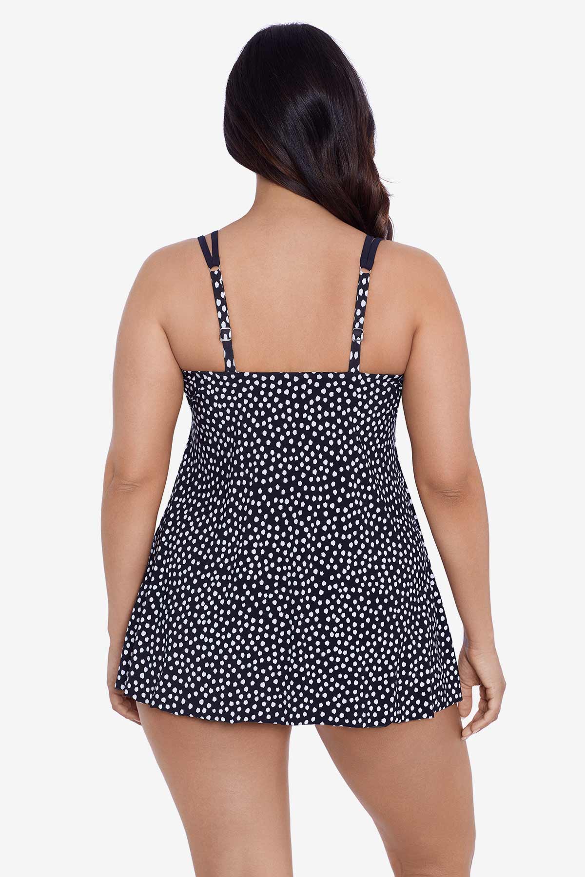 Woman turned away wearing a black and white polka dot swim dress 