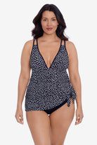 Woman wearing a black and white polka dot swim dress tied at the side