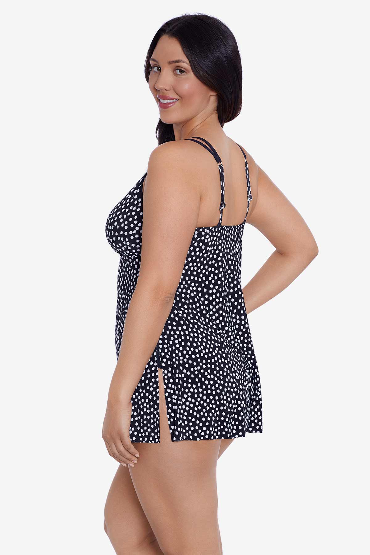 Woman faced left wearing a black and white polka dot swim dress