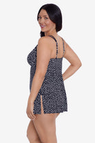 Woman faced left wearing a black and white polka dot swim dress