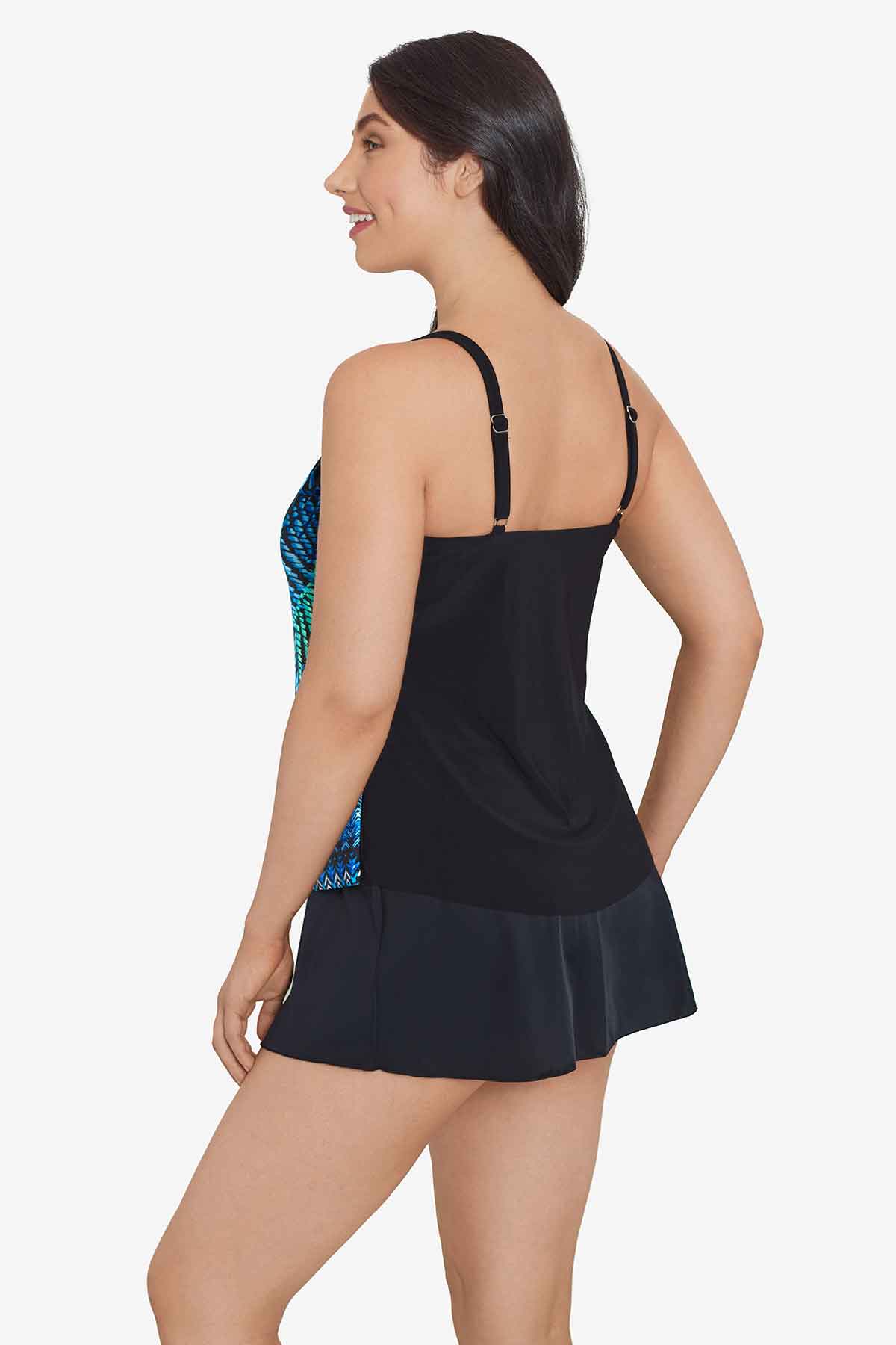 Woman turned left wearing a blue and black palm leaf and tile printed tankini top