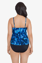 Woman faced away wearing a blue tie dye ruffle tankini top